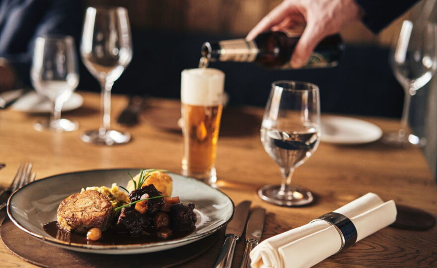 The waiter serves beer with the main course.